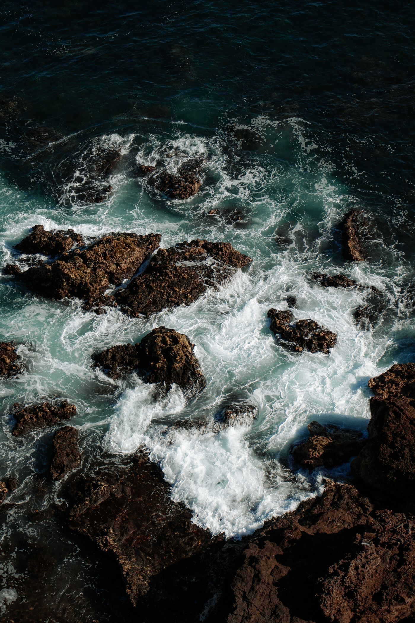 Foaming waves viewed above a rugged coastline, illustrating the Greyjoy brothers’ maritime world.