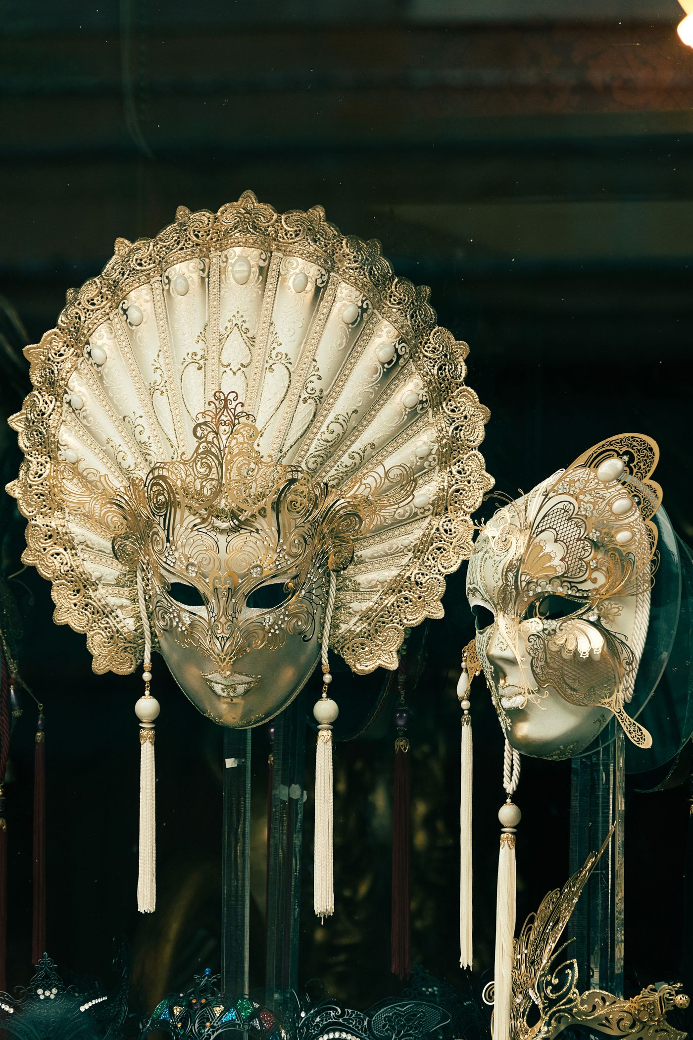 Ornate Venetian masks displayed against dark fabric, illustrating hidden identity.