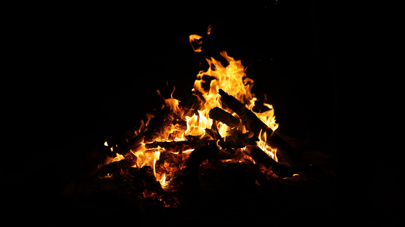 Firelight and flames at night, illustrating belief centred on fire.