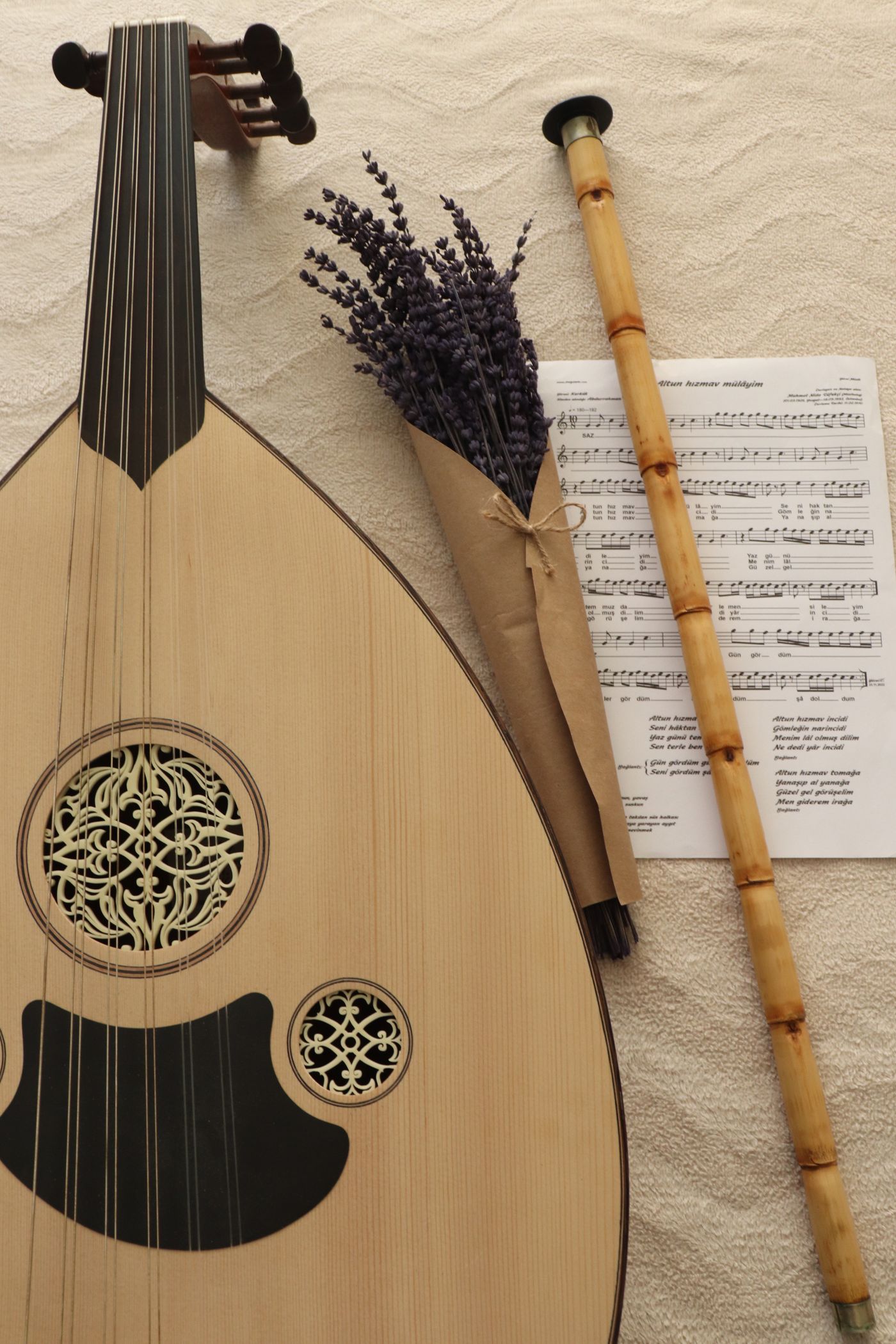 An oud, a ney flute and sheet music arranged together, illustrating the political force of songs.