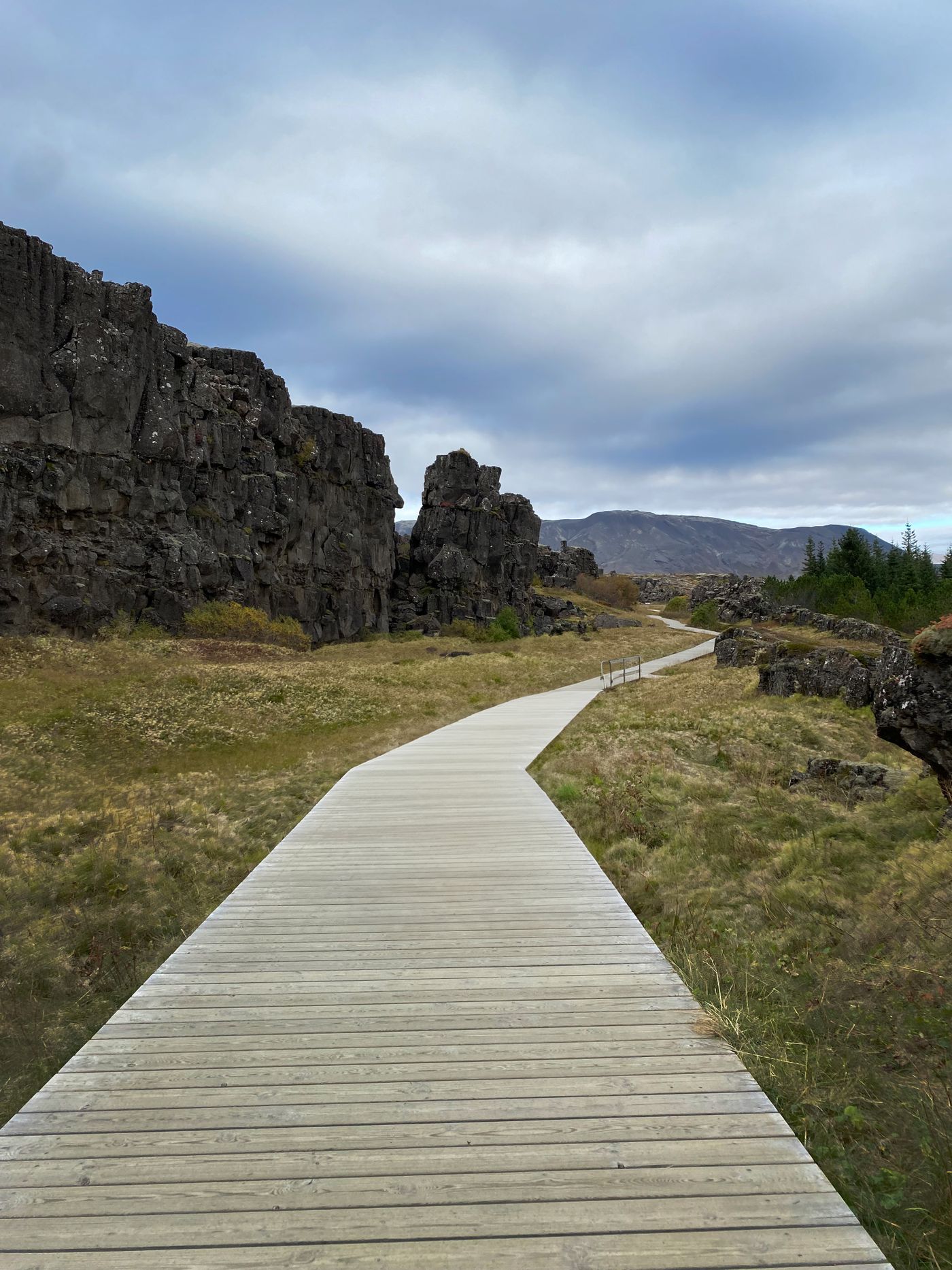 A boardwalk beside the rocky rift formations of Þingvellir National Park in Iceland